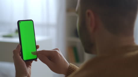 online-shopping-or-ordering-by-app-in-smartphone-man-is-swiping-scrolling-and-tapping-on-sensor-display-green-screen-for-montage-closeup-view